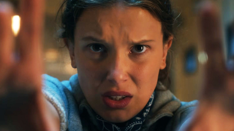 Milly Bobby Brown as Eleven holds up her hands in closeup in Stranger Things