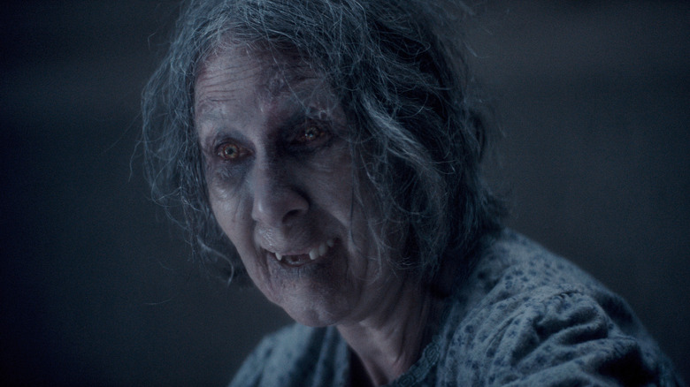 An older woman who's possessed by the Deadites cackling in Evil Dead Burn