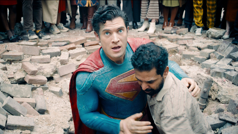 David Corenswet as Superman saving a man from rubble in Superman (2025)