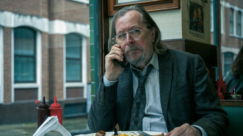 Jackson Lamb on the phone while eating at a restaurant in Slow Horses season 5