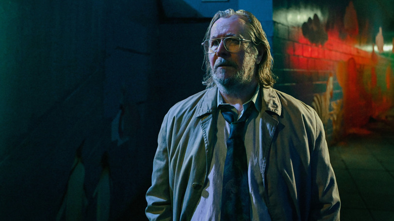 Gary Oldman's Jackson Lamb stands in a London alleyway lit by moonlight in Slow Horses season 5