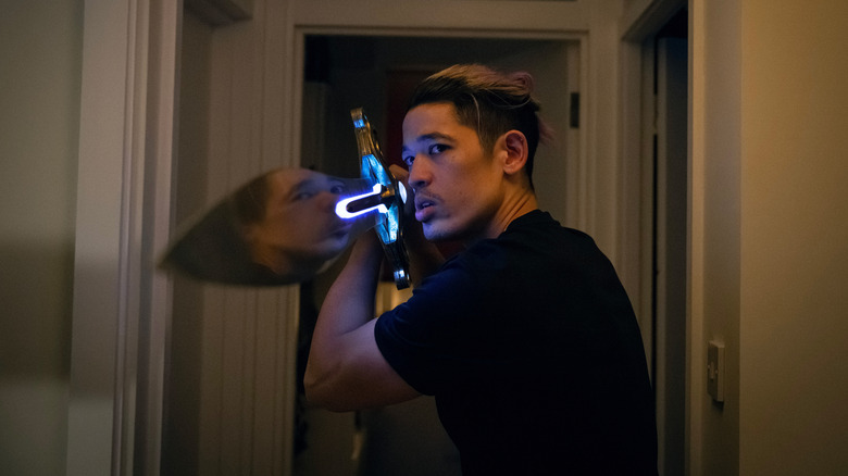 Christopher Chung's Roddy Ho holding a sword and pointing it at something off camera in Slow Horses season 5