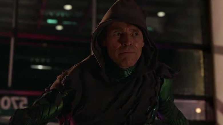 Norman Osborn (Willem Dafoe) usa um capuz marrom esfarrapado sobre o traje de Goblin Verde com os olhos arregalados no Homem-Aranha: De jeito nenhum para casa