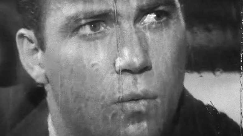 William Shatner's Robert Wilson is seen in closeup with his face against a window pane covered in rain water in The Twilight Zone