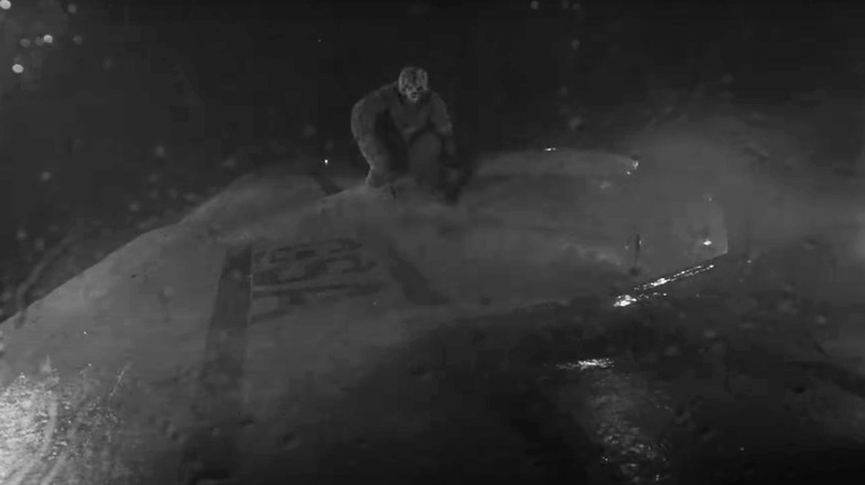 Nick Cravat's gremlin stands on the wing of a plane in The Twilight Zone