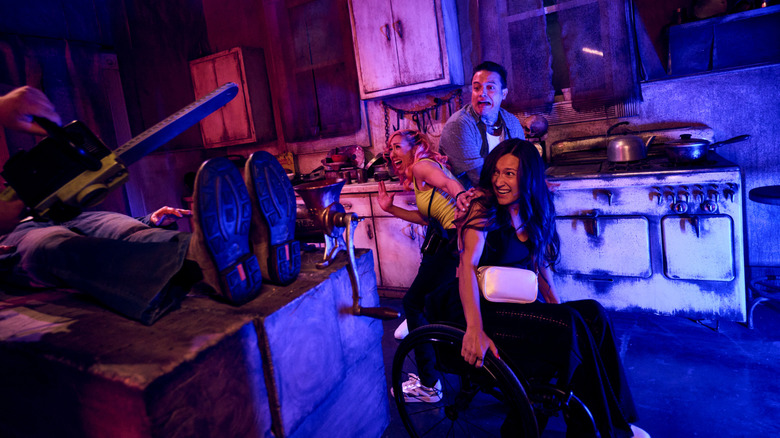 A group being terrorized by someone with a chainsaw in Horror Unleashed
