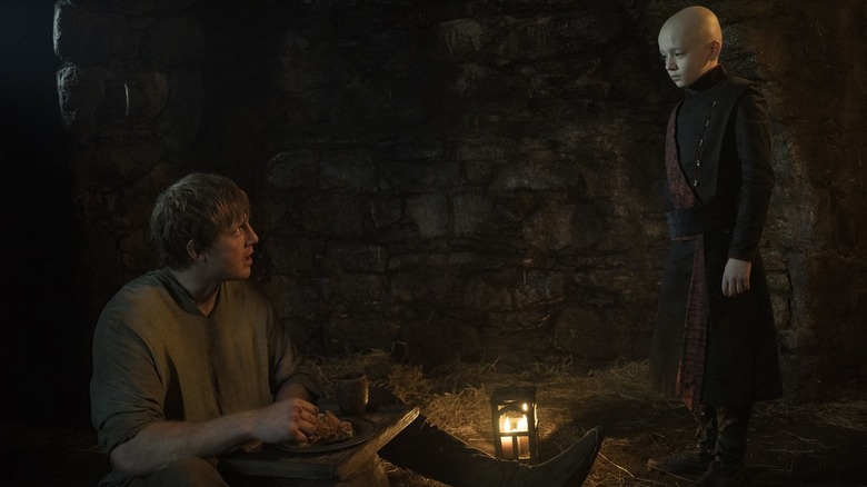 Peter Claffey as Ser Duncan the Tall sitting in a dungeon looking up at Dexter Sol Ansell as Egg in A Knight of the Seven Kingdoms