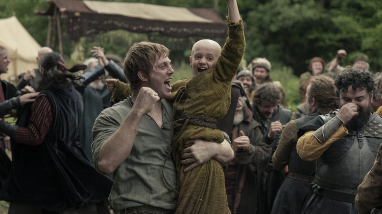 Peter Claffey as Ser Duncan the Tall picking up Dexter Sol Ansell as Egg and celebrating with a crowd in A Knight of the Seven Kingdoms