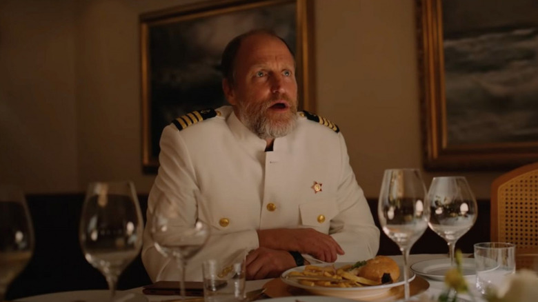 வூடி ஹாரெல்சன் கேப்டன் தாமஸ் ஸ்மித் சாப்பாட்டு மேசையில் அமர்ந்து தி ட்ரையாங்கிள் ஆஃப் சோகத்தைப் பார்த்து அதிர்ச்சியடைந்தார்