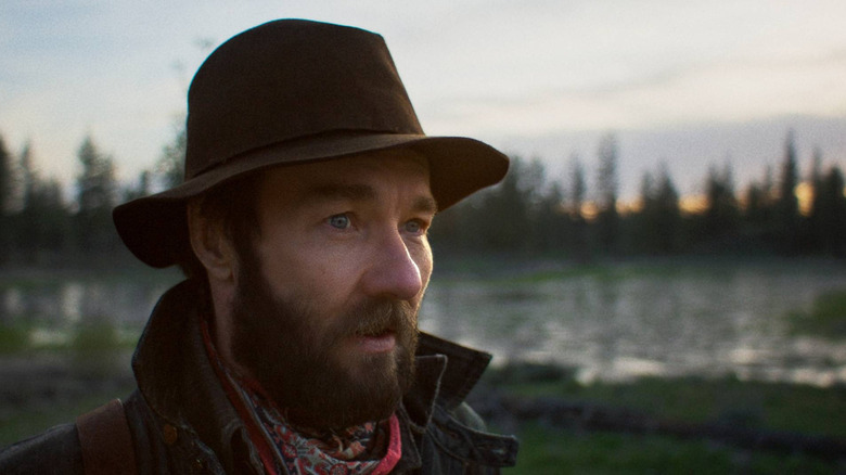 Robert Grainier (Joel Edgerton) wearing a hat outdoors in Train Dreams