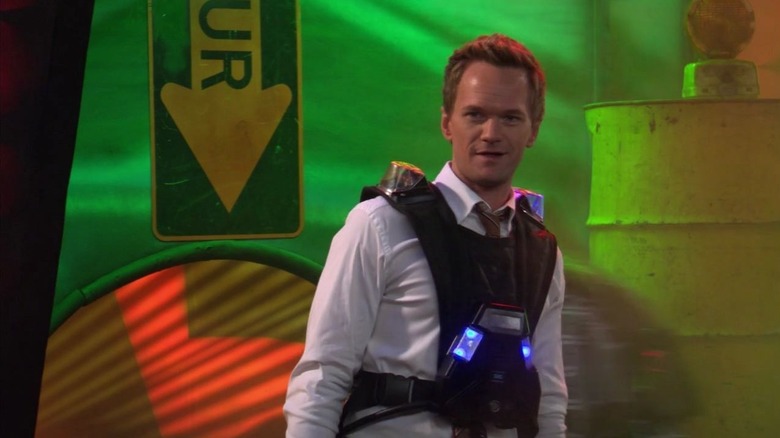 Neil Patrick Harris as Barney Stinson wearing a laser tag vest in a neon laser tag arena on How I Met Your Mother