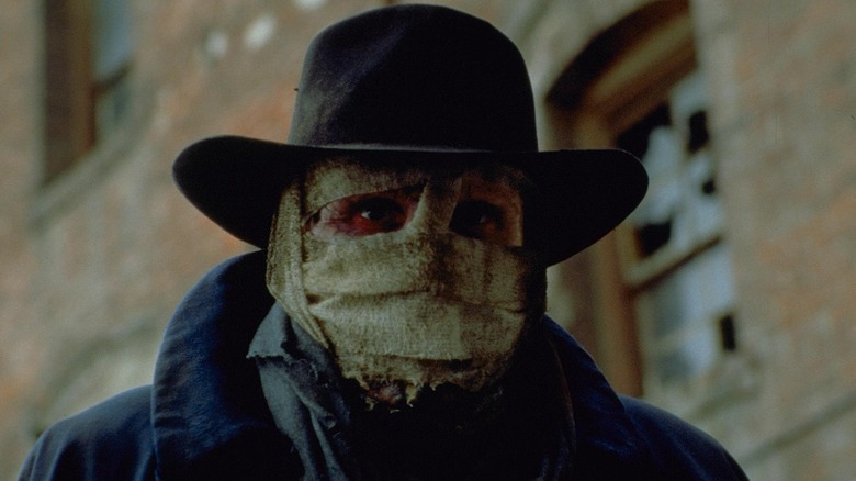 Liam Neeson as Peyton Westlake with his face bandaged up in an alleyway in Darkman