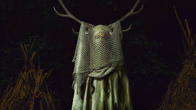 The Antler Queen standing in the snow at night on Yellowjackets