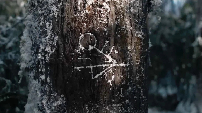 The Yellowjackets symbol carved into a tree