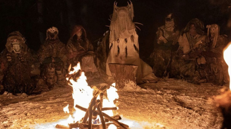 The Antler Queen and her masked hunters huddled around a campfire on Yellowjackets