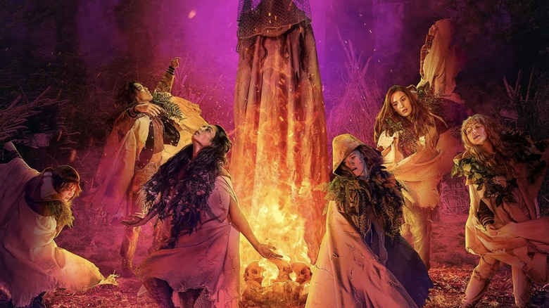 Yellowjackets season 3 poster: Natalie, Tai, Lottie, Van, Misty, and Shauna dancing around the Antler Queen in fire