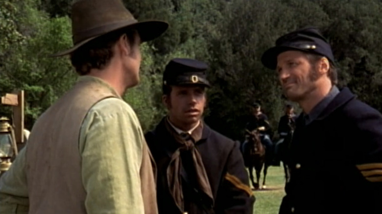 Winter Corporal in Taylor Sheridan stands between David Becruvet Sergeant Mcai and a man with his back to the camera in Dr. Queen Medicine Woman