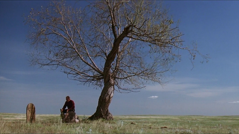 William Munny sitting by a grave in Unforgiven