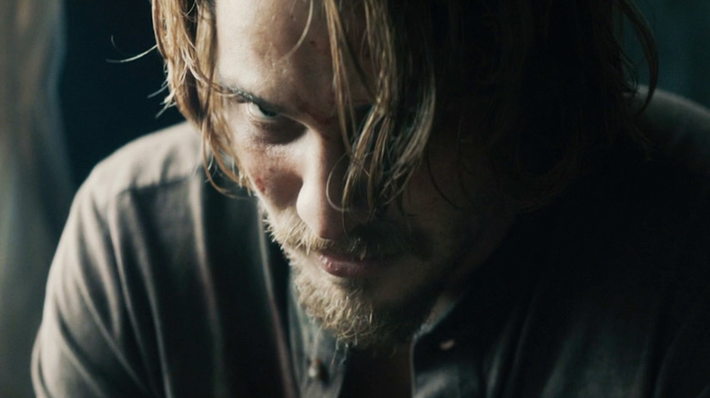 Luke Grimes' Nick Brenner is seen in closeup looking angry in Into The Ashes