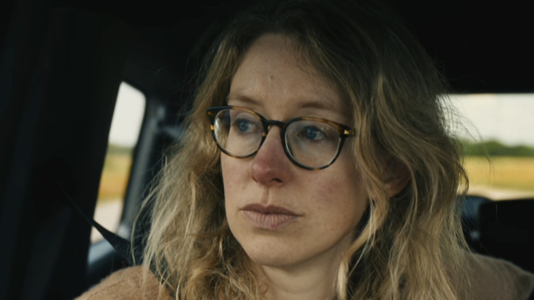 Elizabeth Holmes sitting, tearful, in an SUV on the way to prison in You Can See Everything