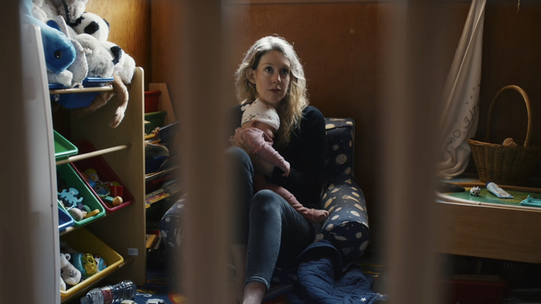 Elizabeth Holmes sits with her infant child in a playroom in You Can See Everything