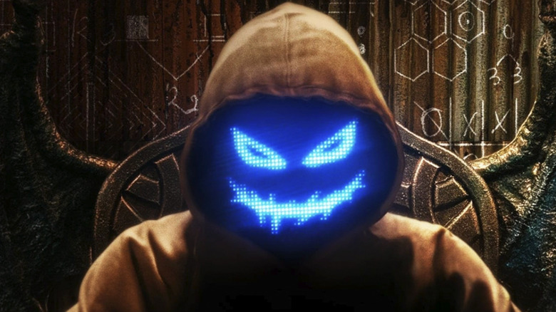 The sinister host of the devil's plan sits in a chair