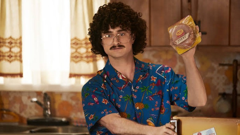 Weird Al holding a pack of bologna in Weird: The Al Yankovic Story