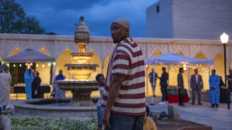 Mahershala Ali as Latif wearing a taqiyah prayer cap and standing in the courtyard of a mosque in Your Mother Your Mother Your Mother