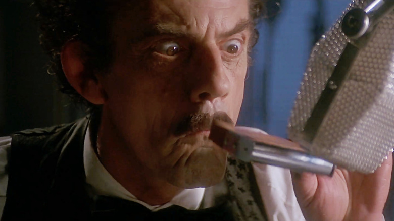 झोल्टनच्या भूमिकेत ख्रिस्तोफर लॉयड रेडिओलँड मर्डर्समध्ये हार्मोनिका वाजवत आहे