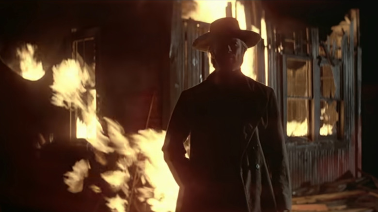 The Stranger standing in front of a fire in High Plains Drifter