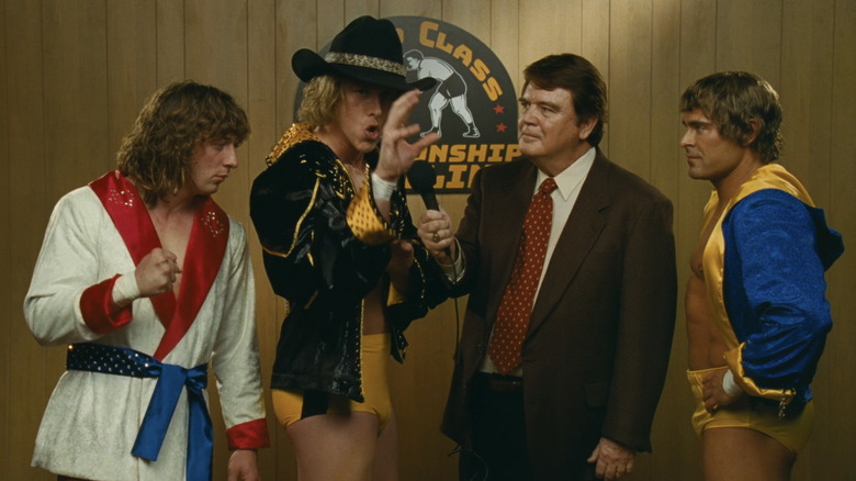Jeremy Allen White's Kerry Von Erich, Harris Dickinson's David Von Erich, and Zac Efron's Kevin Von Erich stand talking to an interviewer in The Iron Claw