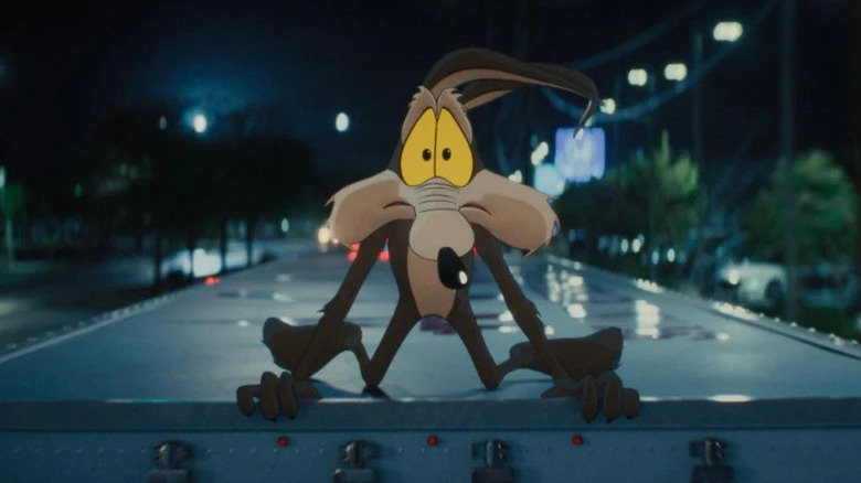 Wile E. Coyote hanging on to a truck