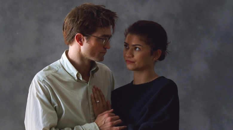 Robert Pattinson as Charlie holding Zendaya as Emma posing for their engagement photos in The Drama