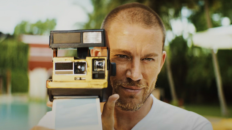 Slater King of Channing Tatum holding a polaroid camera in Blink Twice