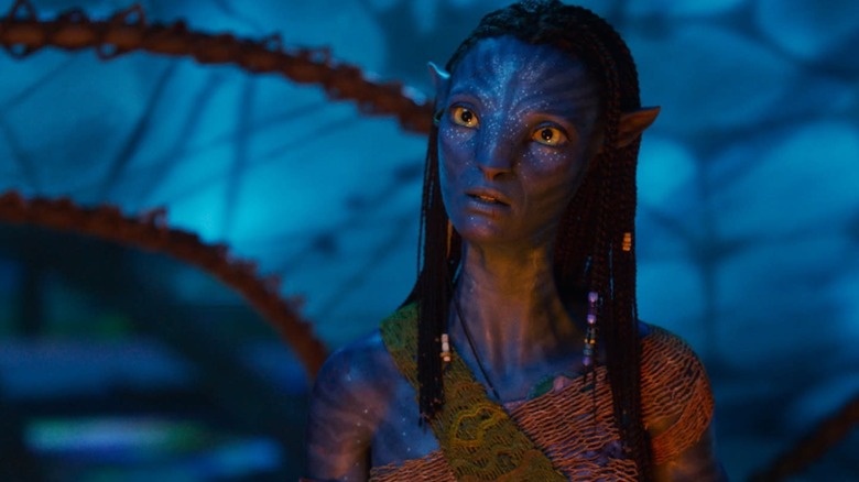 Zoe Saldana as Neytiri with her head cocked to the side in Avatar: Fire and Ash